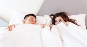 Couple in bed having sex
